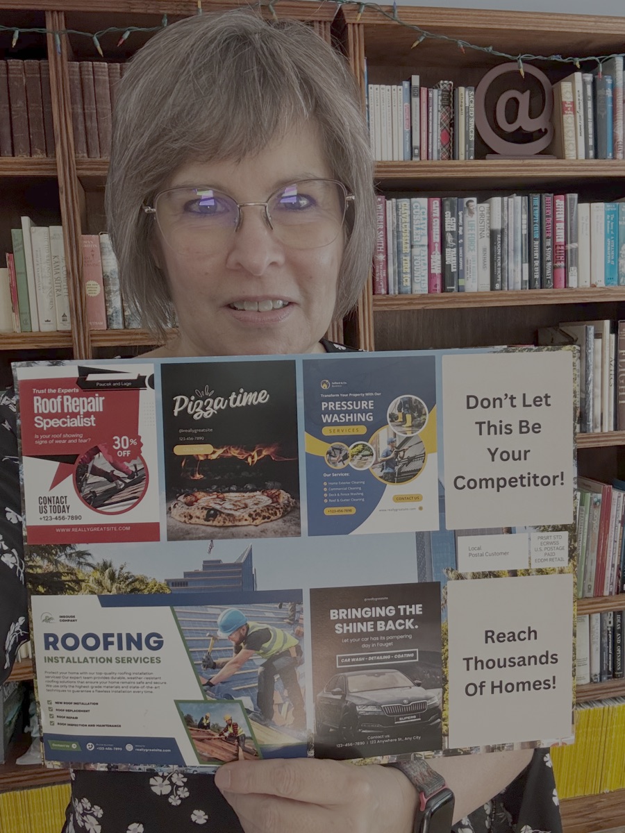 Terza Ekholm holding a full-size Community Cards postcard with local business ad spaces